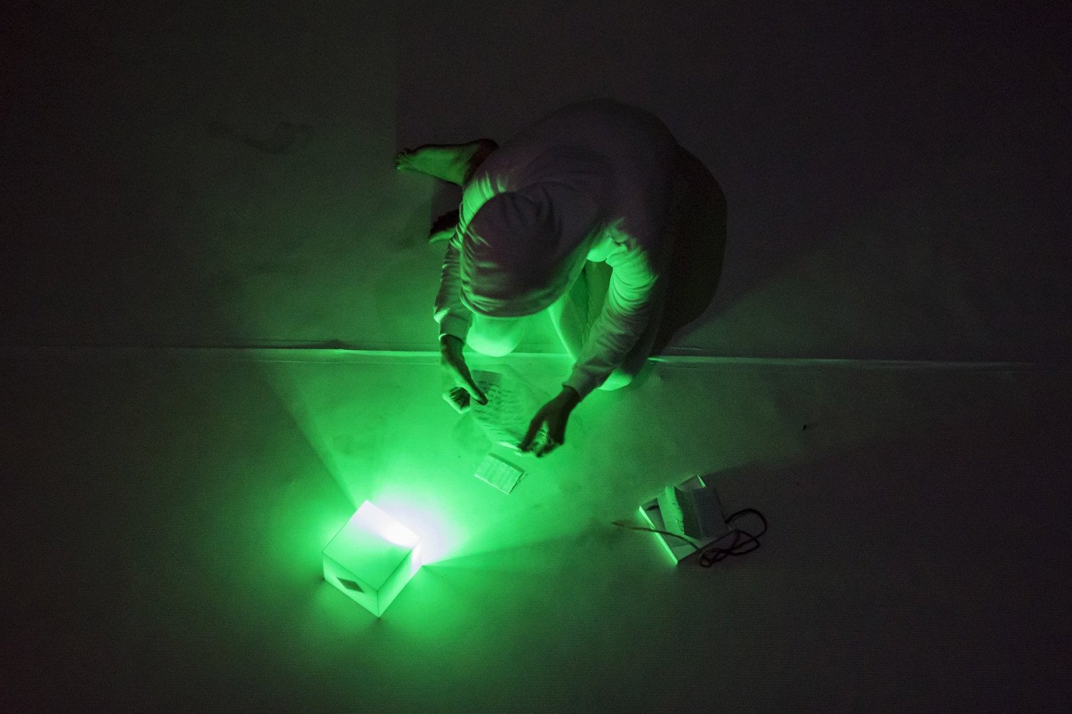 Draufsicht auf ein grünliches Licht mit einer Person, die ein Blatt Papier in der Hand hält. 